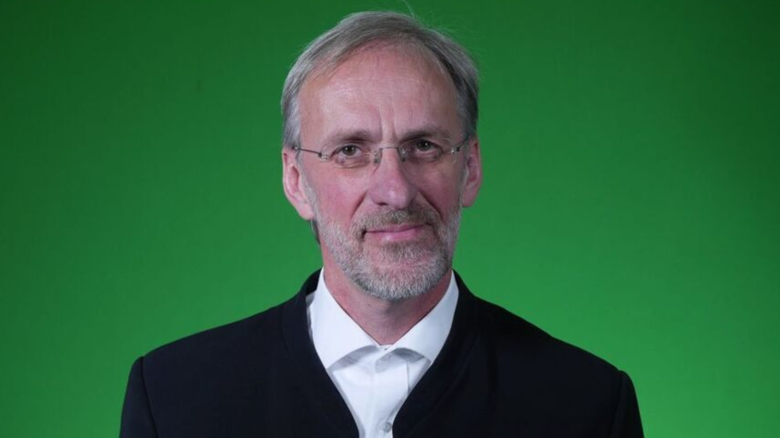 Porträt von Prof. Heribert Nacken. Grüner Hintergrund 