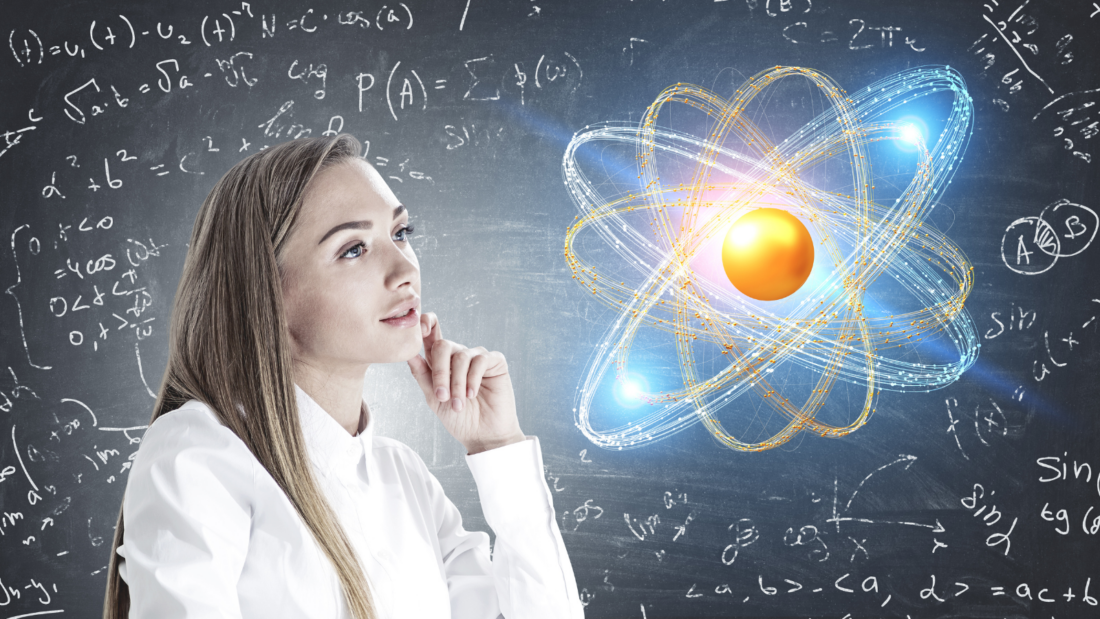 Frau, die auf die Darstellung eines Atoms schaut