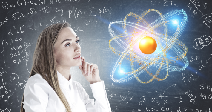 Frau, die auf die Darstellung eines Atoms schaut