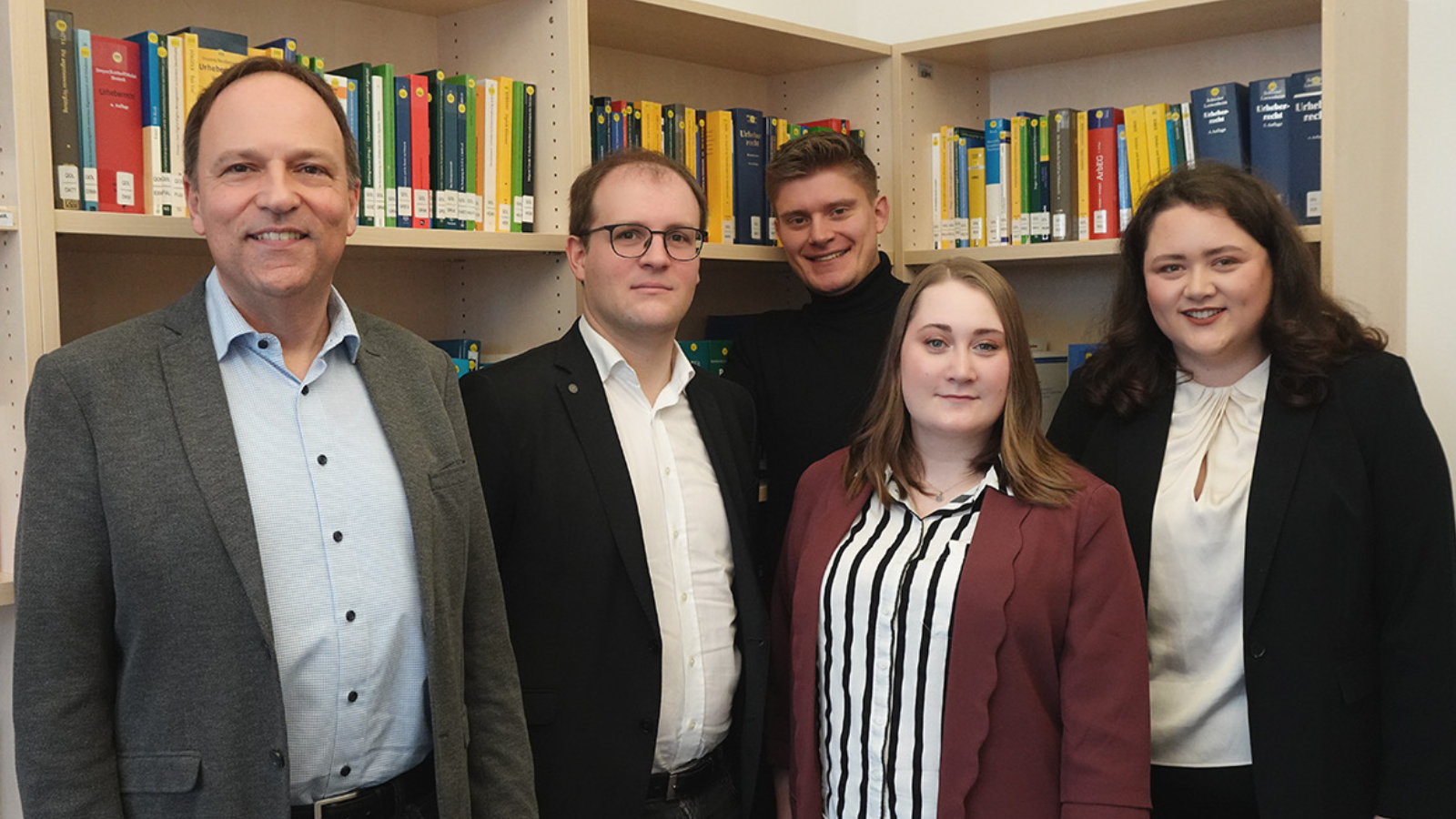 Team Rechtsinformation vor einem Bücherregal