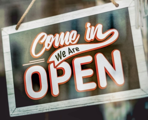 Schild mit Aufschrift: Come in, we're open