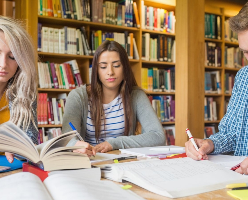 Studierende sitzen schreibend in der Bibliothek