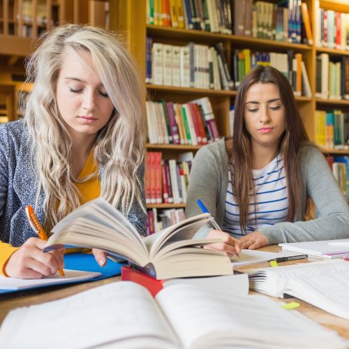 Studierende sitzen schreibend in der Bibliothek