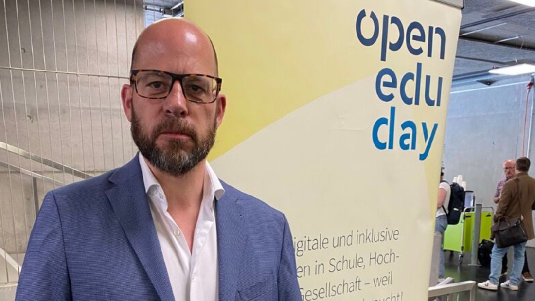 Markus Deimann vor dem Open Edu Day Banner