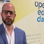 Markus Deimann vor dem Open Edu Day Banner