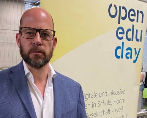 Markus Deimann vor dem Open Edu Day Banner