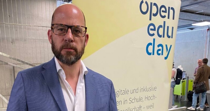 Markus Deimann vor dem Open Edu Day Banner